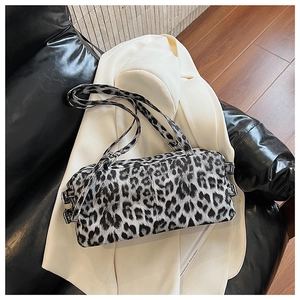 Détail du sac cylindre imprimé léopard avec boucles argentées sur blazer blanc