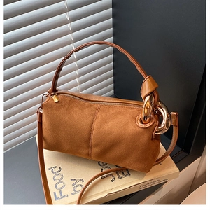 Detail of vintage brown suede handbag with thick gold chain and smooth leather trim