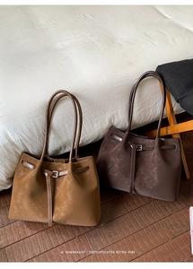 Detail shot of the suede tote bag with slim buckle strap and vintage texture