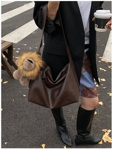 Détail d'un grand sac cabas marron foncé avec un joli porte-clés en peluche lion