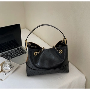 Details der schwarzen gesteppten Hobo-Tasche mit Goldkette und schicken Requisiten