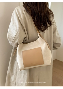 Detailed back view of a minimalist faux suede tote bag worn by a model in warm light