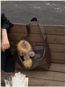 Détail d'un sac hobo en cuir PU marron avec porte-clés lion en peluche, style automne