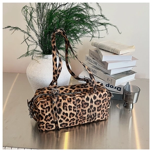 Détail du sac Boston imprimé léopard avec boucles métalliques et texture en fausse fourrure