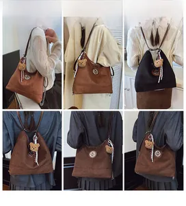 Détail du grand sac cabas mat avec breloque ours et différentes options de porté pour femme