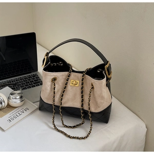 Detailansicht der Kontrast-Tasche mit beigem Wildleder, schwarzem Steppmuster und Schloss