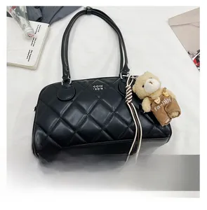 Quilted black leather handbag featuring a cute teddy bear charm and fashion accessories