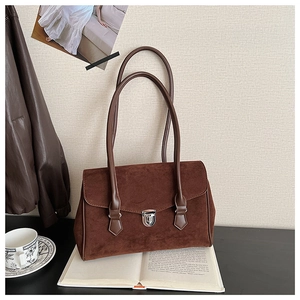 Detail of vintage dark brown suede shoulder bag with silver buckle and smooth leather trim