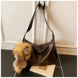 Détail du grand sac hobo vintage marron café avec breloque en peluche et boucle métallique
