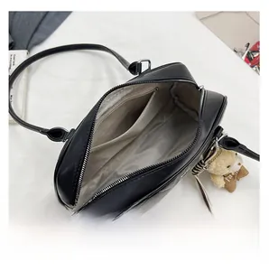 Detail showing the internal storage space of the black bag with a zip and beige lining