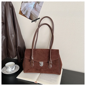 Macro shot of dark brown frosted texture handbag with silver twist lock and dual handles
