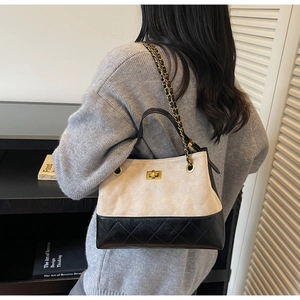 Detailaufnahme der beigen und schwarzen Stepptasche mit Goldkette und Drehverschluss