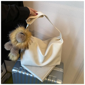 Vue détaillée du sac en cuir PU blanc avec un grand pendentif pompon en fausse fourrure marron