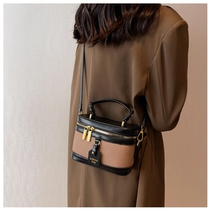 Vue arrière d'un mannequin portant le sac seau en toile marron avec bordure en cuir noir