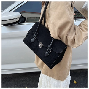 Detail view of the silver metal clasp and matte suede texture on the black shoulder bag