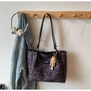 Detail of leopard print tote bag with beaded tassel and fashion brand label