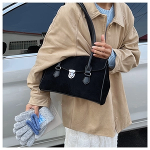 Detail of silver metal buckle on black matte suede shoulder bag for winter fashion