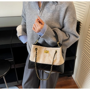 Detail der gesteppten beige-schwarzen Tragetasche mit goldenem Drehverschluss und Kette