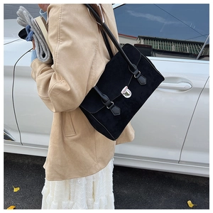 Detail of elegant black frosted suede underarm bag with silver metallic press lock and strap