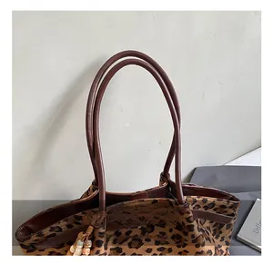 Detailansicht der Leopard-Tragetasche mit braunen Griffen und Vintage-Holzperlenanhänger