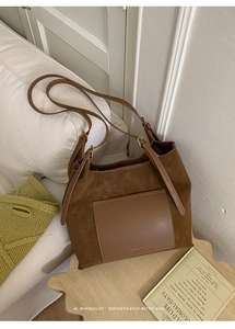 Detail of brown suede and leather stitching on large tote bag with adjustable strap