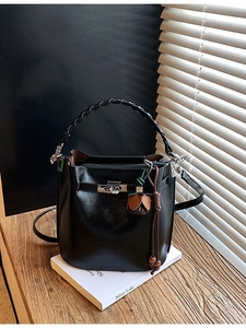 Classic black leather bucket bag with woven handle and metallic turn-lock closure