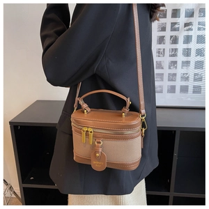 Détail du sac seau vintage en toile et cuir marron avec zips et chaîne dorée