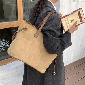 Detail of suede leopard tote bag with leather straps and gold buckle on grey wool coat