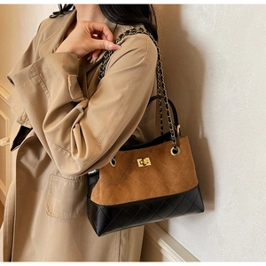 Detailaufnahme der zweifarbigen Stepptasche mit goldener Kette und Metalldrehverschluss
