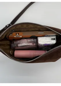 Vue de dessus du sac bandoulière en daim montrant la capacité intérieure et le zip