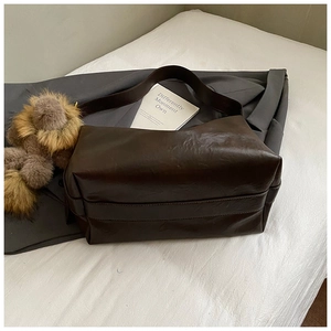 Gros plan d'un sac cabas vintage marron au cuir souple avec pendentif en peluche