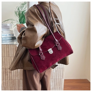 Detail of burgundy suede tote bag featuring a silver twist lock on a vintage shoulder bag