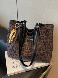 Chic leopard print tote bag with black leather straps and decorative wooden beads