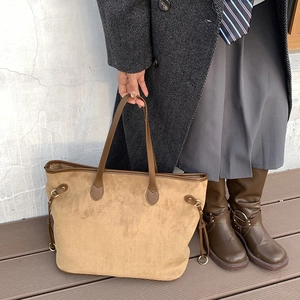 Detail of premium camel suede tote bag showing metallic ring buckle and side texture