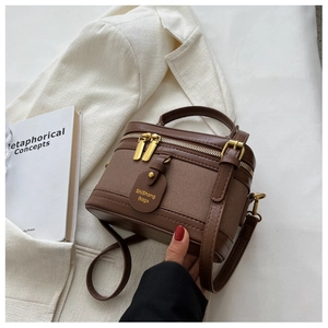 Détail du sac seau vintage en toile marron avec garniture en cuir et bandoulière