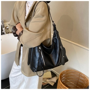 Detail of black Hobo shoulder bag with long tassel and heart-shaped pendant accessory