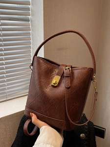 Retro brown bucket bag in crackle texture leather with gold twist-lock and shoulder strap