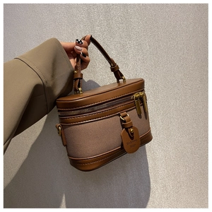 Détails de la couture en cuir et fermeture éclair métallique d'un sac seau marron rétro
