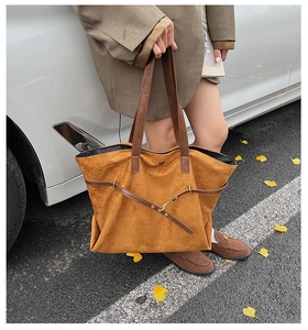 Brown suede tote bag shown in an outdoor lifestyle setting with camel blazer outfit