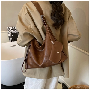 Detail view of brown leather tote bag with detachable crescent coin purse and strap