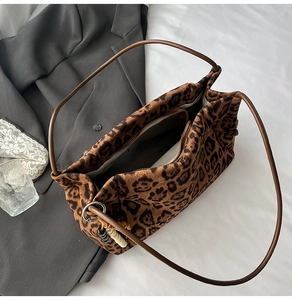 Close-up of leopard print suede tote bag with inner zipper pocket and beaded charm
