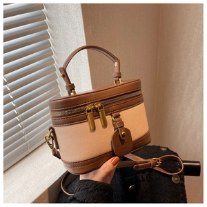 Détail du sac seau vintage avec garniture en cuir marron et texture en toile beige