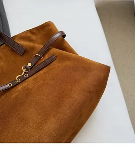 Close-up of brown suede tote bag featuring durable texture and premium leather strap