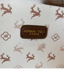 Détail d'un sac cabas en cuir grainé avec motif élan et étiquette de marque MOKANI YOLE PARIS