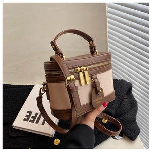 Détail du sac boîte rétro avec coutures en cuir et doubles fermetures éclair dorées
