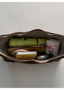 Vue intérieure du sac à bandoulière marron foncé montrant sa grande capacité