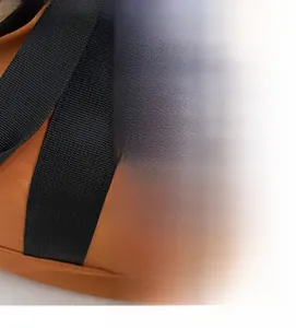 Detail of orange high-density nylon canvas bag with black woven handle and logo tag