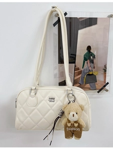 White quilted crossbody bag with metal logo and brown teddy bear charm accessory