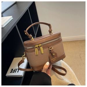 Détail du sac seau vintage marron avec double fermeture éclair et étiquette élégante