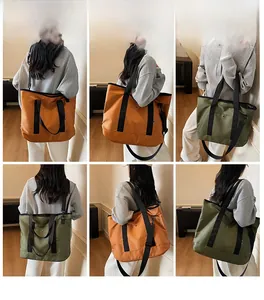Detail view of large canvas tote bag showing handheld and crossbody carrying options
